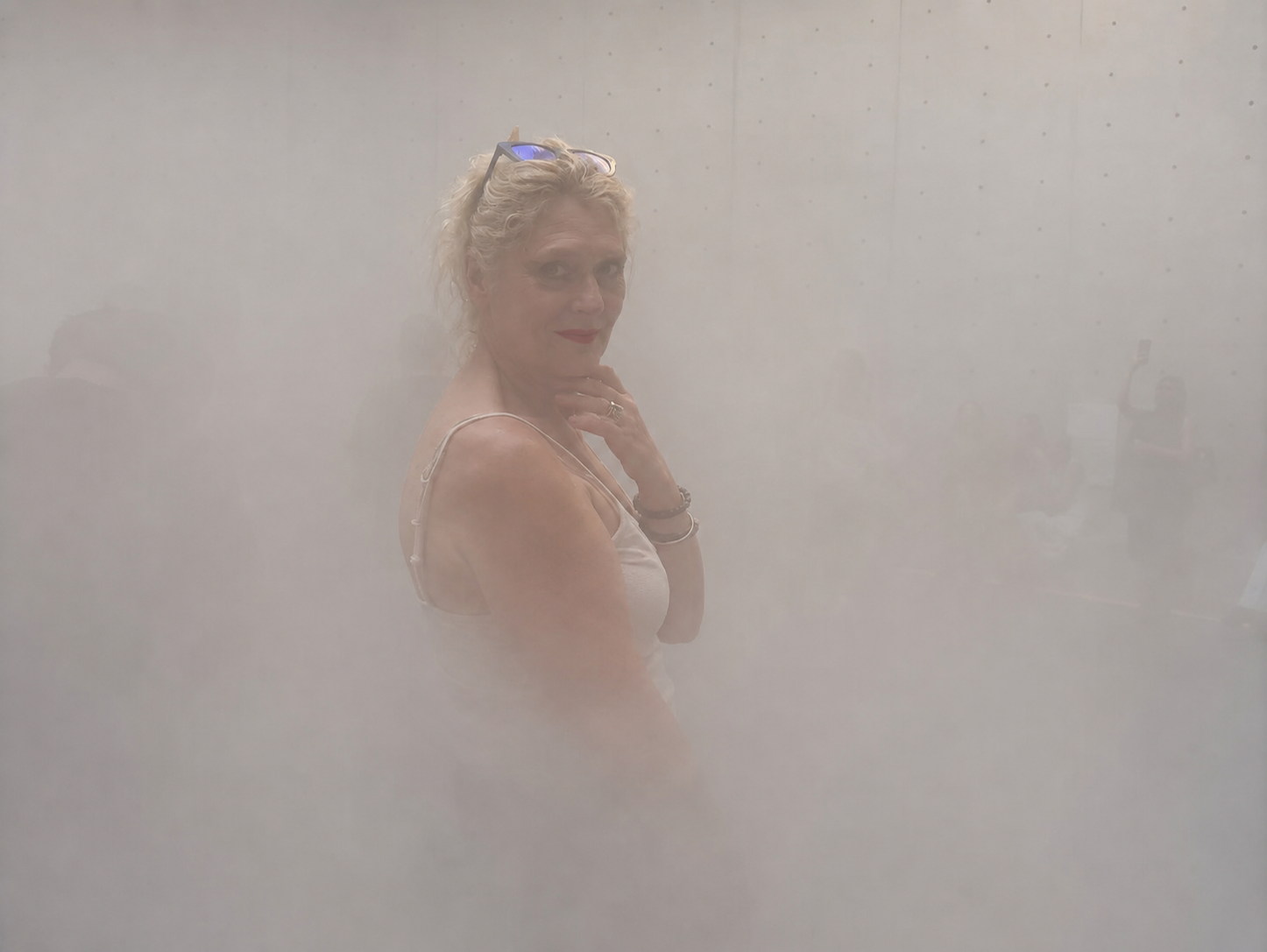Self-portrait of Anna Khann standing in a pale, mist-filled space.